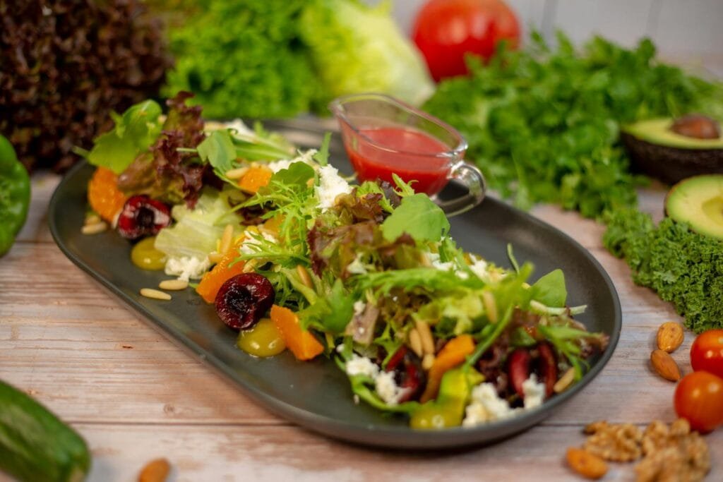 10 Delicious Diabetic-Friendly Recipes You Can Try Today A vibrant salad with mixed greens, nuts, and fruits, set on a stylish black plate, ideal for a healthy meal.